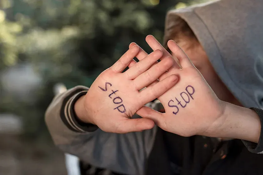 stop child abuse . Upset abused frightened little boy, stop hand gesture close up portrait with copy space.